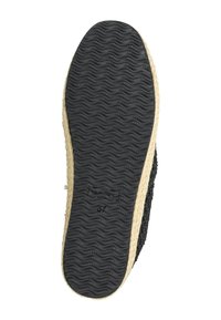 Suela de zapato negra texturizada con una base de goma y un borde similar a yute. Presenta un patrón de banda de rodadura ondulado para mayor agarre.