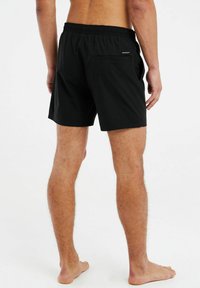 Zwarte zwembroek met een elastische tailleband, voorzien van een achterzak en een gladde textuur, ontworpen voor comfort en bewegingsvrijheid.