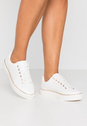 Witte sneakers met een glad bovenwerk van synthetisch materiaal, een ronde neus, gouden oogjes en een platte rubberen zool met een subtiele gouden rand.