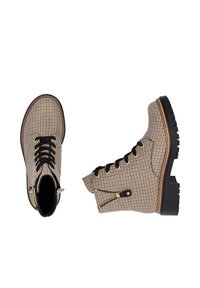 Bottines chevronnées marron avec des lacets noirs, des fermetures éclair dorées et des semelles en caoutchouc texturé. Conçues pour la durabilité et l'adhérence.