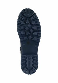 Suela de bota de goma negra con patrones de banda de rodadura profundos para tracción, que presenta una superficie texturizada y un tacón redondeado para estabilidad.