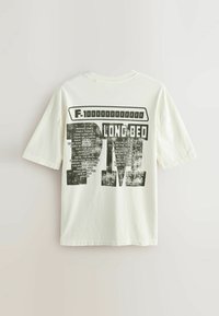 Hvid oversized T-shirt med sort grafisk tekst "F-100000000000 LONG BED" og en liste over sangtitler på bagsiden.