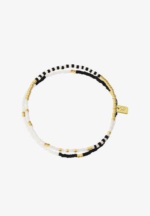 Bracelet double rangée de perles alternant perles noires, blanches et dorées, avec un petit pendentif rectangulaire en or gravé d'un cœur.