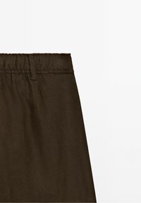 Pantalon en tissu marron foncé avec une ceinture élastique et une passants de ceinture, présenté sur un fond blanc uni.