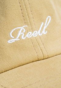 Kappenförmiger Hut aus leicht beigefarbenem Stoff mit strukturierter Oberfläche. Verfügt über das weiße, gestickte "Roell"-Logo und sichtbare Nähdetails.