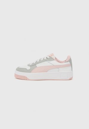 Zapatilla baja blanca con detalles en rosa claro y gris, cordones blancos, suela gruesa y suela exterior texturizada sobre un fondo liso.