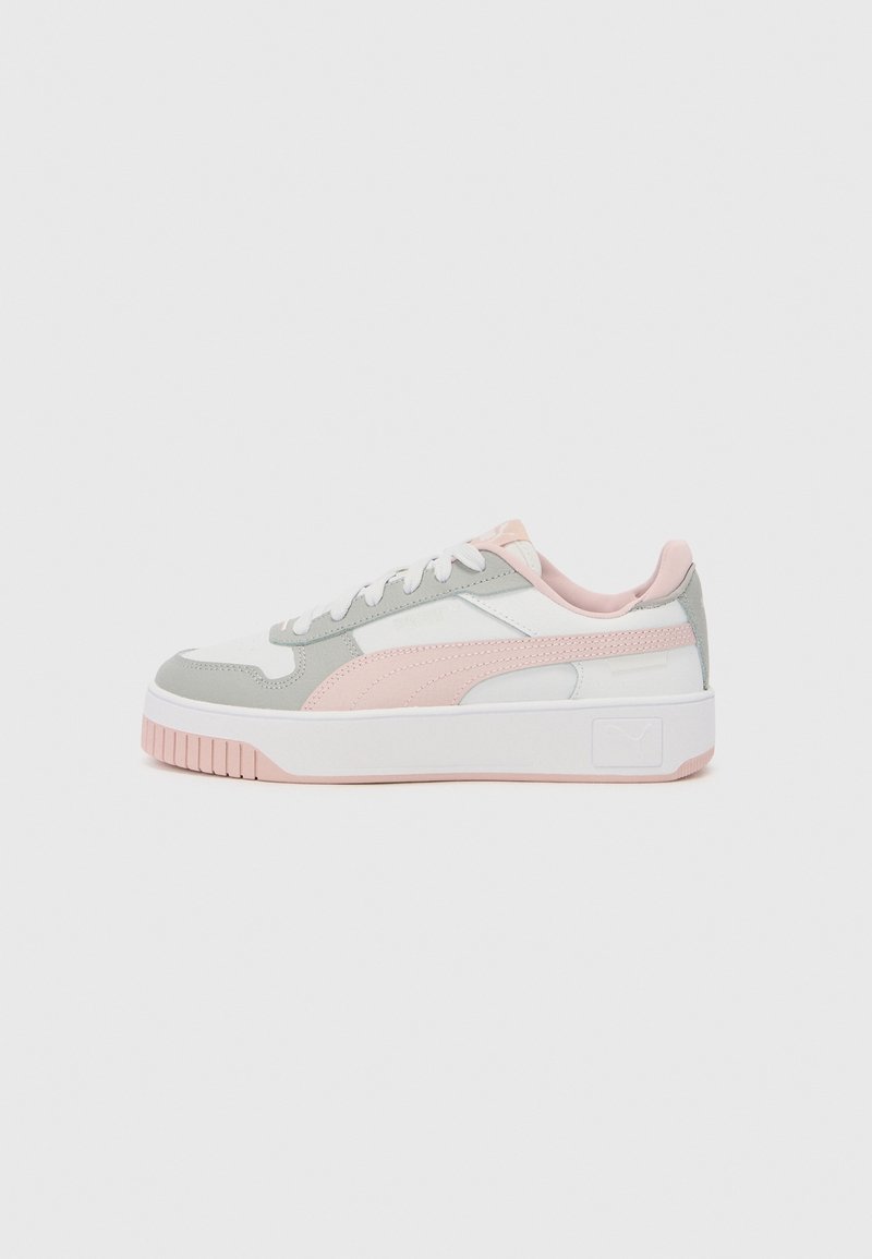 Basket basse blanche avec des accents rose clair et gris, lacets blancs, semelle épaisse et semelle extérieure texturée sur un fond uni.