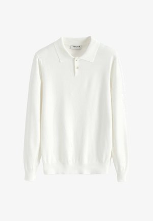 Pull polo blanc à manches longues en tissu doux et texturé. Il présente un col classique et une patte de boutonnage à trois boutons. Poignets et ourlet côtelés.