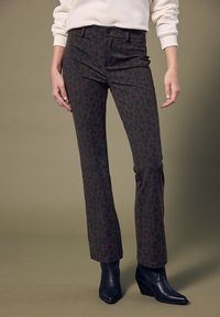 Bruine panty met luipaardprint in een slim fit, met voorzakken en een hoge taille. Gecombineerd met zwarte enkelboots.