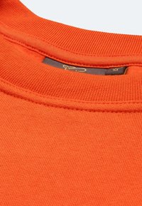 Felpa arancione con colletto a girocollo a coste. Presenta una texture morbida e un'etichetta interna. Il tessuto è liscio, con dettagli di cuciture visibili.