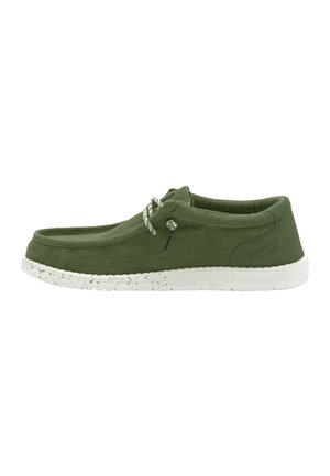 Scarpa slip-on casual verde oliva con suola bianca a spruzzi e lacci a corda bianchi, progettata per il comfort e l'uso quotidiano.