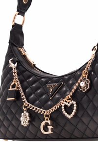 Borsa a tracolla nera trapuntata con hardware dorato, dotata di un logo triangolare e ciondoli decorativi che includono un cuore, un fiore e un lucchetto.