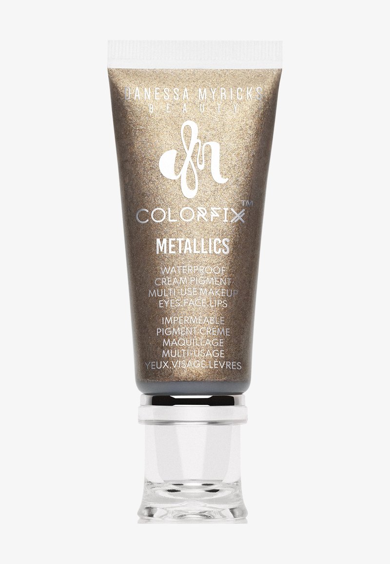 Metallic crème pigment in een gouden tube met een doorzichtige basis. Bevat een zilveren logo en meertalige tekst. Waterproof, multifunctioneel voor ogen, gezicht en lippen.