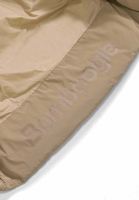 Beige gewatteerde jas met een gladde textuur en subtiele "Bombogie" branding in een lichte tint langs de zoom. Lichtgewicht, casual ontwerp.