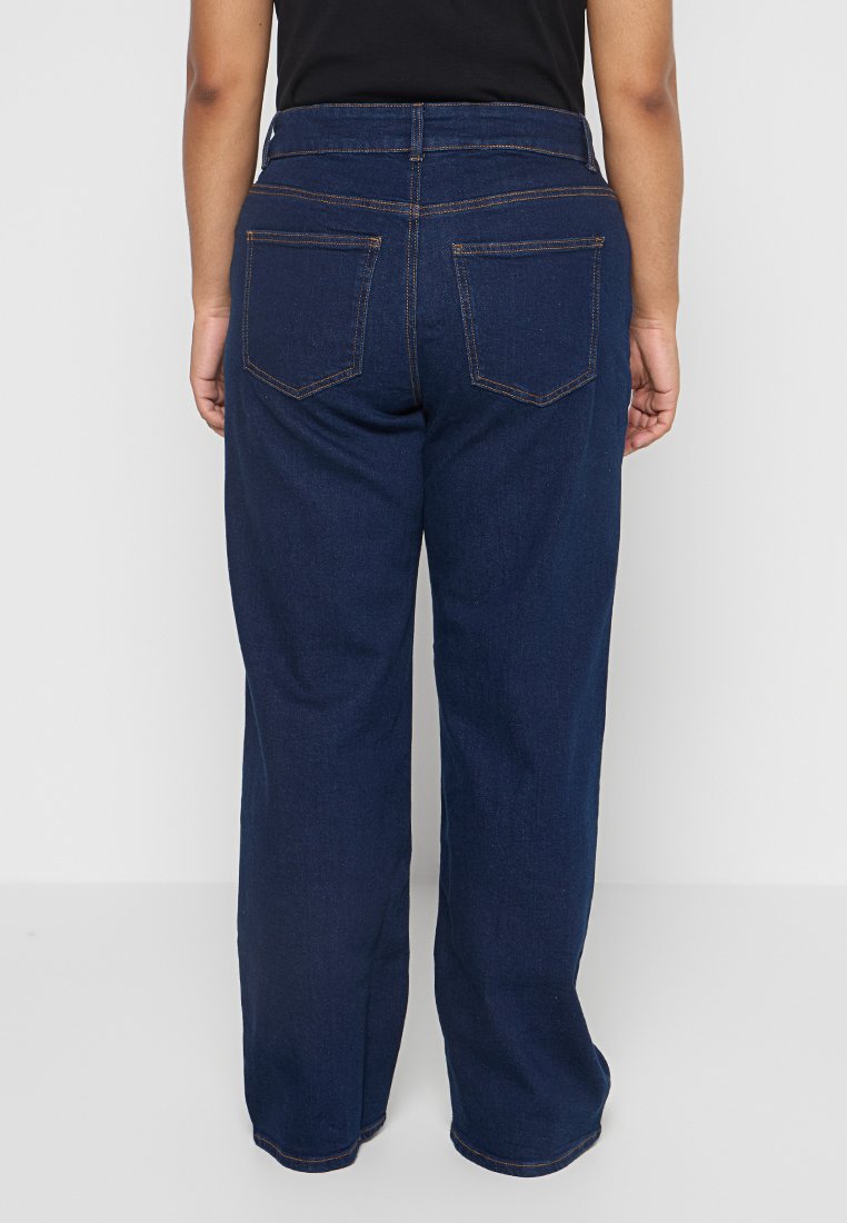 Pantalons en denim bleu foncé avec une taille haute, une coupe large et des poches arrière. Finitions avec des coutures visibles et une texture lisse.