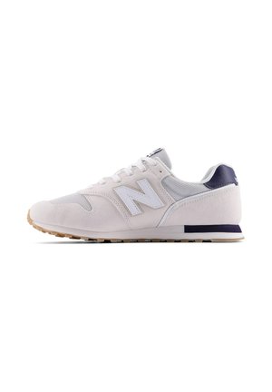 Sneaker New Balance grigio chiaro e bianco con pannelli in mesh e suede, suola in gomma e dettaglio sul tallone blu navy, vista laterale su sfondo bianco.