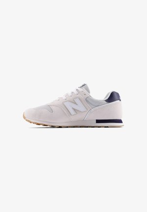 Sneaker New Balance grigio chiaro e bianco con pannelli in mesh e suede, suola in gomma e dettaglio sul tallone blu navy, vista laterale su sfondo bianco.
