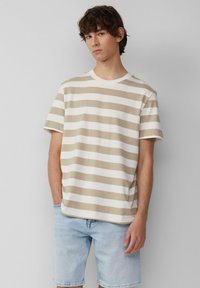 Beige en witte gestreepte t-shirt met korte mouwen, van katoen, ronde hals, relaxed fit, gecombineerd met lichte denim shorts.