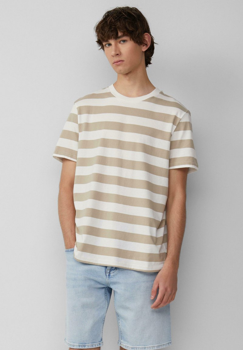 Beige en witte gestreepte t-shirt met korte mouwen, van katoen, ronde hals, relaxed fit, gecombineerd met lichte denim shorts.