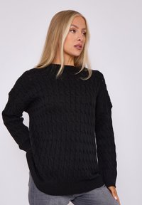 Schwarzer Strickpullover mit einem strukturierten Muster, Rundhalsausschnitt und langen Ärmeln, der einen lockeren Schnitt und gerippte Abschlüsse aufweist.