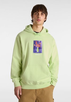 Mint green hoodie in soft fabric, featuring a front pocket and a floral graphic patch with purple accents. Drawstring hood and relaxed fit.