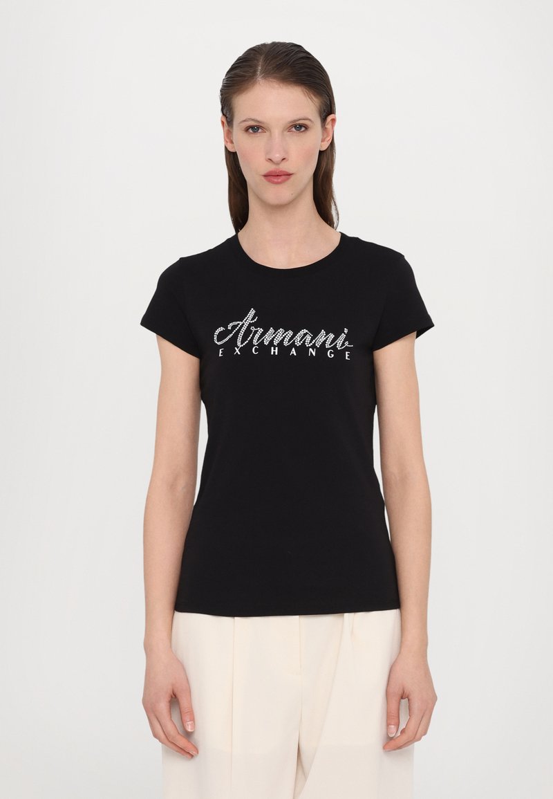 Schwarzes Baumwoll-T-Shirt mit kurzen Ärmeln, auf der Vorderseite mit einem silbernen Glitzer-Logo "Armani Exchange". Glatte Textur, klassischer Schnitt.