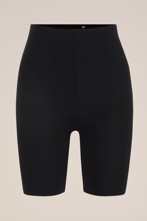 Schwarze, nahtlose Biker-Shorts mit hoher Taille aus glattem, dehnbarem Stoff und mittlerer Oberschenkellänge vor beigem Hintergrund.