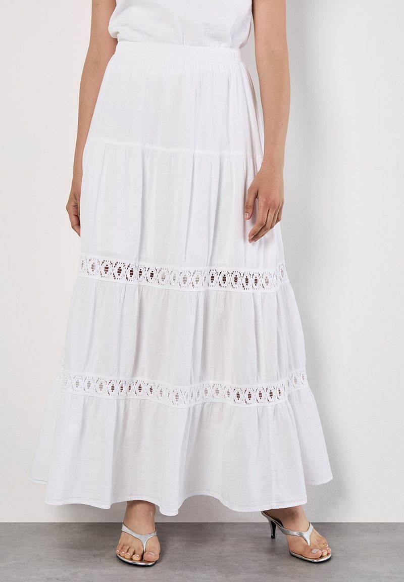 Gonna maxi bianca a strati realizzata in tessuto leggero con dettagli in pizzo sull'orlo. Presenta un elastico in vita per una vestibilità comoda.