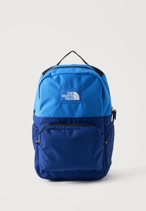 Dvojfarebný modrý a námornícky modrý batoh s predným vreckom na zips, sieťovanými bočnými vreckami, čiernou rúčkou a bielym logom The North Face na hornom prednom paneli.