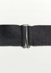 Sangle élastique noire avec fermoir à crochet et œillet en métal argenté sur un fond clair uni.