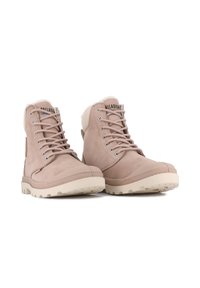 Bottines en daim rose clair avec des accents crème, semelle en caoutchouc et lacets gris ; elles présentent un intérieur doux et un logo sur la languette.