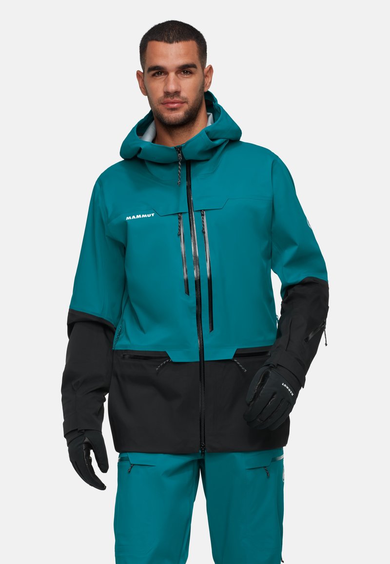 Teal- und schwarze wasserdichte Jacke mit Kapuze, Reißverschlusstaschen und verstellbaren Bündchen. Entworfen für Outdoor-Aktivitäten.