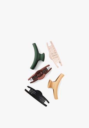 Fem assorterede farvede plastik hårklemmer med åbent kamdesign arrangeret på en hvid baggrund.