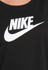 Svart t-shirt i bomull med rund hals; har en framträdande vit Nike-logga och en swoosh-design tryckt i fet stil.