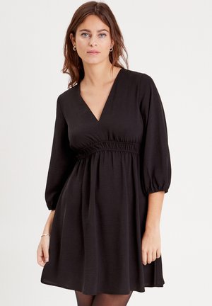 Schwarzes Kleid aus leichtem Material mit tiefem V-Ausschnitt, elastischem Bund und dreiviertellangen Puffärmel. Weiche Textur und fließendes Design.