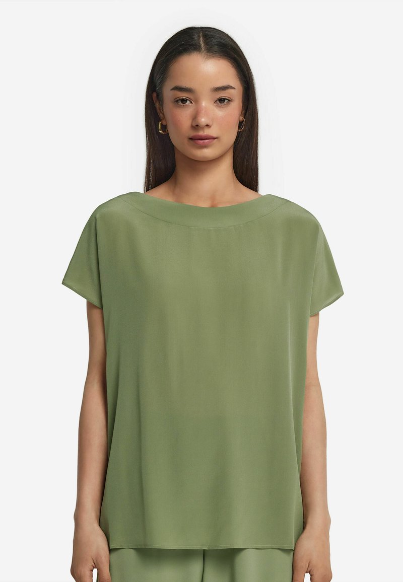 Kortärmad blus i ljusgrön, med en bred båturringning, mjukt tyg och en avslappnad passform som faller lätt.