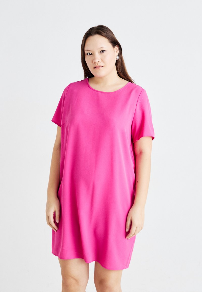 Vestido de manga curta, até ao joelho, em tecido rosa brilhante, com decote redondo e corte solto, apresentando bolsos laterais. Textura suave, design simples.