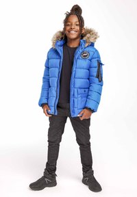Blauwe puffer jacket met een bontomzoomde capuchon, voorzien van horizontale stiksels, een logo patch op de borst en zijzakken met rits. Draag het met zwarte jeans en laarzen.
