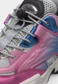 Gros plan sur une basket Buffalo en mesh rose, bleu et blanc, avec des lacets élastiques et le logo sur la languette et le panneau latéral.