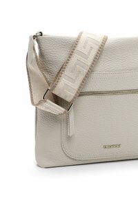 Beige leren schoudertas met een gestructureerde afwerking, voorzien van een ritszak en een verstelbare schouderriem met een patroon in lichte tinten.