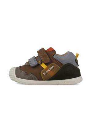 Zapatilla infantil marrón y gris con detalles amarillos, dos tiras ajustables y suela blanca con etiqueta "biomecanics."