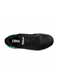 Baskets de sport noires avec une tige en mesh, fermeture à lacets et accents de semelle verte. Présente un embout texturé et une marque sur la languette.