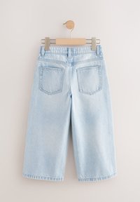 Lyseblå denim culottes med høj talje, to baglommer og lige ben. Hænges på en træclips med en metalhæk.
