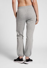 Grijze sweatpants met een elastische tailleband en gathered cuffs. Draag ze met zwarte sneakers met witte accenten. Zacht katoenmixmateriaal.