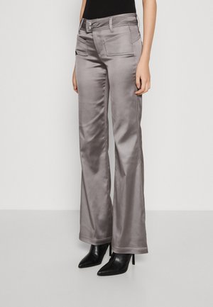 Šedé saténové široké kalhoty s dvěma předními kapsami a pasem na dva knoflíky, spojené s černými lodičkami s špičatou špičkou. Hladký a jemný textura.