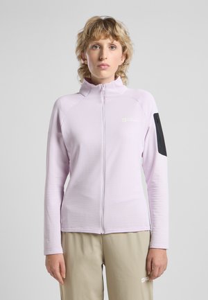 Giacca a zip di un leggero viola con texture a coste e colletto alto, caratterizzata da una tasca con zip nera sulla manica sinistra.
