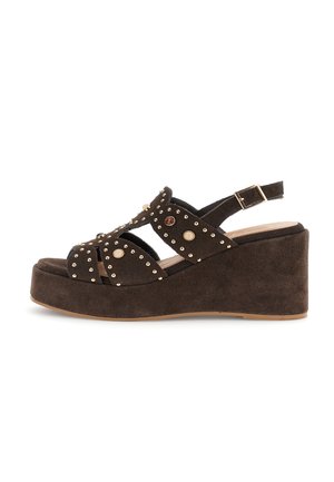 Bruine suède sleehak sandaal met enkelbandje, gouden studs en decoratieve ronde accenten op meerdere bandjes.