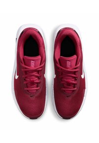 Punaiset verkkokankaiset urheilukengät valkoisilla kumipohjilla, joissa on pyöreä kärki, nauhoitusjärjestelmä ja Nike-logo sivussa ja kielekkeessä.