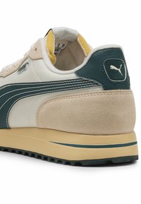 Puma-sneakers med beige semsket skinn og grønt lær på overdelen, hvit midtdel, gul fôr og en tykk kremfarget såle med teksturert grep.