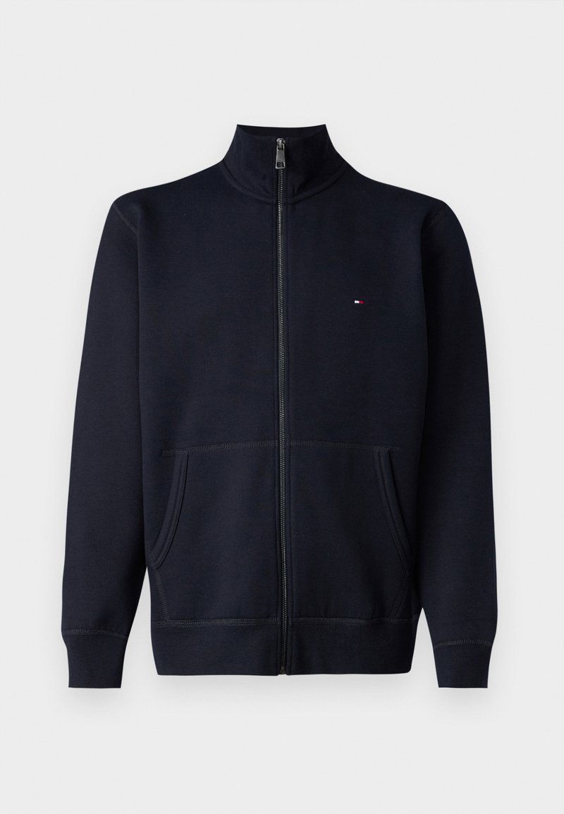 Navyblaue Zip-Up-Sweatjacke aus weichem Stoff, mit hohem Kragen, zwei vorderen Taschen und einem kleinen Logo auf der Brust.